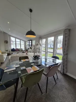 a dining room with a glass table and chairs at The Retreat 2 bedroom lodge with sauna! in Walton-on-the-Naze