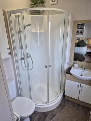 a bathroom with a shower and a toilet and a sink at The Retreat 2 bedroom lodge with sauna! in Walton-on-the-Naze