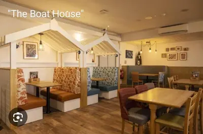 a restaurant with tables and chairs and a booth at The Retreat 2 bedroom lodge with sauna! in Walton-on-the-Naze