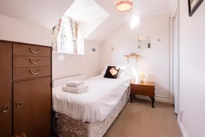 a bedroom with a bed and a dresser and a window at 3 Barley Lands, Aldeburgh in Aldeburgh