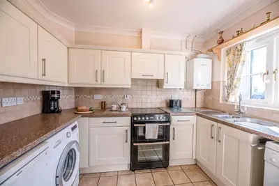 a kitchen with white cabinets and a stove top oven at 3 Barley Lands, Aldeburgh in Aldeburgh