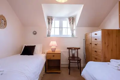 a bedroom with two beds and a window at 3 Barley Lands, Aldeburgh in Aldeburgh