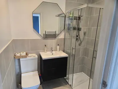 a bathroom with a shower and a sink and a toilet at Newly Built Studio Apartment in Stevenage