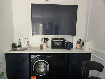 a kitchen with a washing machine and a microwave at Newly Built Studio Apartment in Stevenage