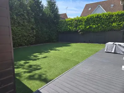 a backyard with a lawn with a table on it at Newly Built Studio Apartment in Stevenage