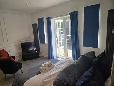 a living room with a bed and a tv at Newly Built Studio Apartment in Stevenage
