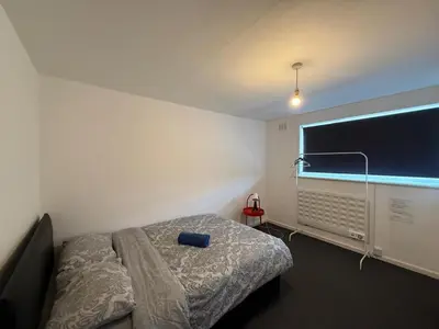 a bedroom with a bed and a large window at 3 Bedroom Apartment in Rayleigh Town Centre with Balcony in Rayleigh