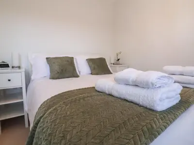 a bedroom with a bed with towels on it at Bay Tree Cottage in Saxmundham