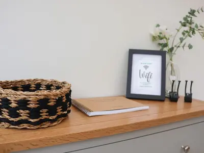 a picture frame and a book on a wooden shelf at Bay Tree Cottage in Saxmundham
