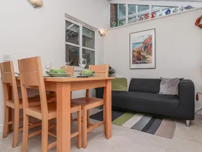 a living room with a table and a couch at Bay Tree Cottage in Saxmundham