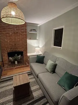 a living room with a couch and a fireplace at Victorian Woodbridge cottage in Melton