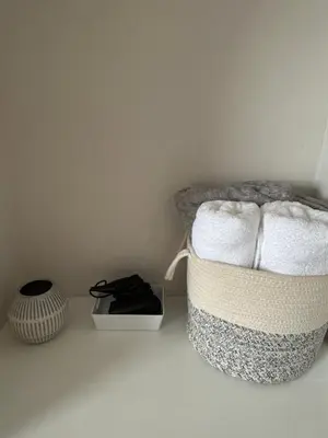 a room with a basket of towels and a vase at Victorian Woodbridge cottage in Melton