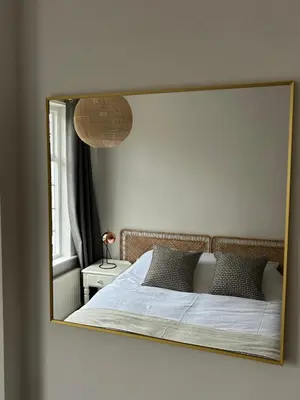 a mirror reflection of a bed in a bedroom at Victorian Woodbridge cottage in Melton