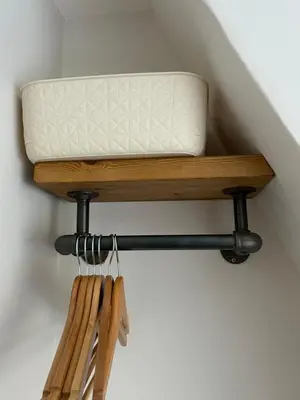 a bench with a pillow on top of a shelf at Victorian Woodbridge cottage in Melton
