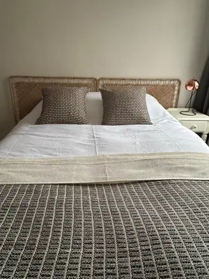 a large bed with white sheets and pillows at Victorian Woodbridge cottage in Melton