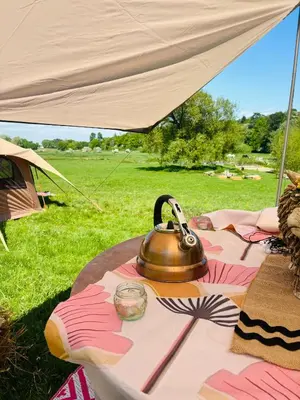 a tea kettle on a table under a tent at Riverside farm Yurt tent Hertford in Hertford