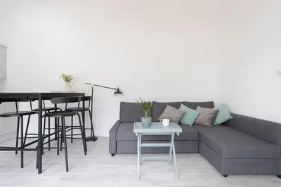 a living room with a couch and a table at Historic Old Stables in Bishops Stortford