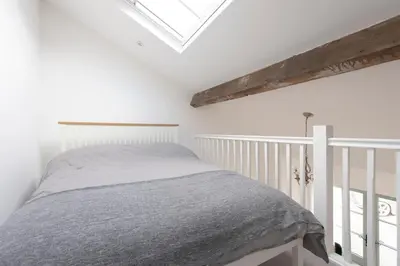 a white bedroom with a bed and a skylight at Historic Old Stables in Bishops Stortford