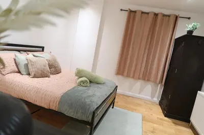 a bedroom with a bed and a dresser at Stylish City-Centre Stay in Chelmsford