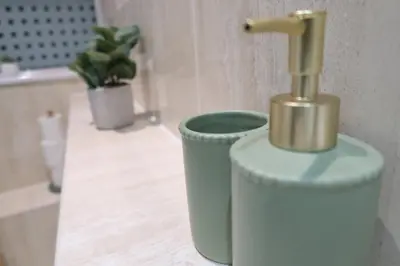 a bathroom with a trash can with a gold pipe at Stylish City-Centre Stay in Chelmsford
