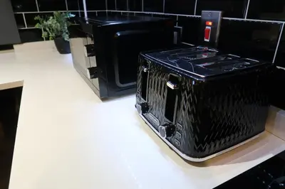 a black microwave sitting on top of a counter at Stylish City-Centre Stay in Chelmsford