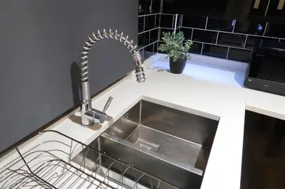 a kitchen sink with a faucet on a counter at Stylish City-Centre Stay in Chelmsford
