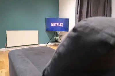 a bed in a room with a netflix sign at Stylish City-Centre Stay in Chelmsford