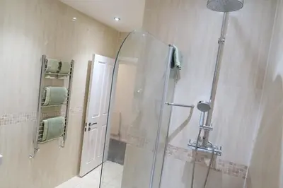 a shower with a glass door in a bathroom at Stylish City-Centre Stay in Chelmsford