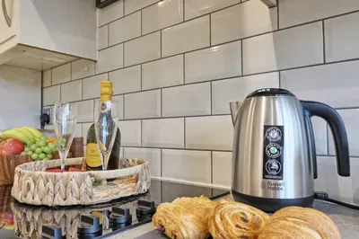 a kitchen counter with a kettle and a basket of bread at Cozy Modern Home Basildon Long stay Contractors Sleeps 6 in Basildon