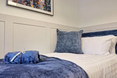a bed with blue and white sheets and pillows at Cozy Modern Home Basildon Long stay Contractors Sleeps 6 in Basildon