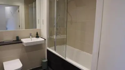 a bathroom with a shower and a toilet and a sink at Cambridge Urban Suite in Cambridge