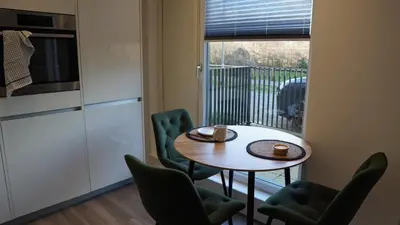 a small table and chairs in a room with a balcony at Cambridge Urban Suite in Cambridge