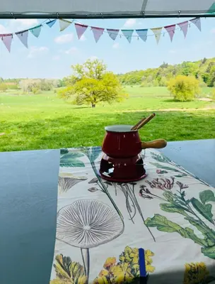 a red pot sitting on a table with a field in the background at Hertford belltent farm stay riverside firepit bbq in Hertford