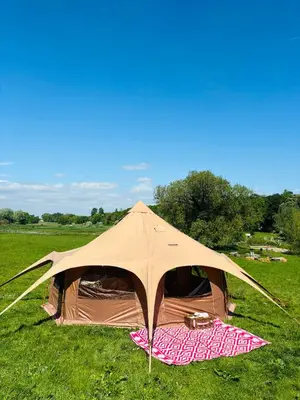 a tent in the middle of a field at Hertford belltent farm stay riverside firepit bbq in Hertford