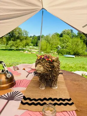 a statue of an elephant sitting on a table with an umbrella at Hertford belltent farm stay riverside firepit bbq in Hertford