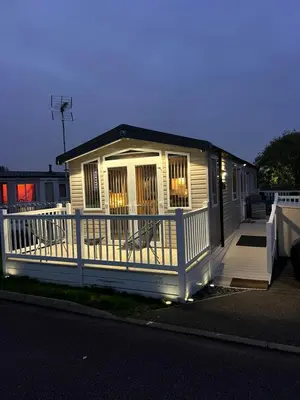 a small house with a porch and a white fence at Mimosa holiday home in Little Clacton