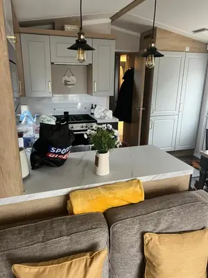 a living room with a couch and a kitchen at Mimosa holiday home in Little Clacton