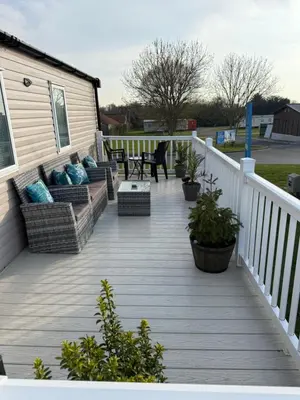 a deck with chairs and a table on a house at Mimosa holiday home in Little Clacton