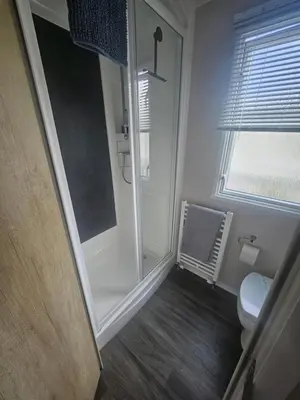 a bathroom with a walk in shower next to a toilet at Mimosa holiday home in Little Clacton