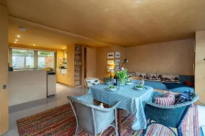 a living room with a table and chairs and a couch at Wodehouse, Eco House - Aldeburgh Coastal Cottages in Aldeburgh
