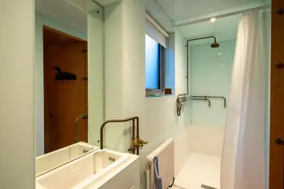 a bathroom with a large sink and a shower at Wodehouse, Eco House - Aldeburgh Coastal Cottages in Aldeburgh