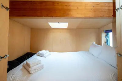 a bedroom with a white bed with towels on it at Wodehouse, Eco House - Aldeburgh Coastal Cottages in Aldeburgh