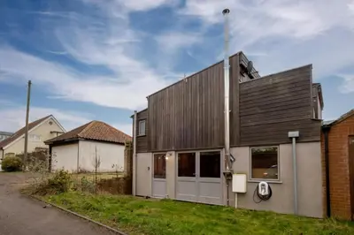 a house with a wooden facade with a garage at Wodehouse, Eco House - Aldeburgh Coastal Cottages in Aldeburgh