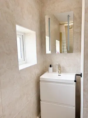 a bathroom with a white sink and a mirror at Home in Upminster in Upminster
