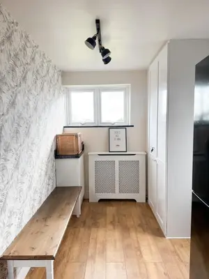 a living room with a bench and a window at Home in Upminster in Upminster