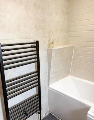a bathroom with a tub and a white bath tub at Home in Upminster in Upminster