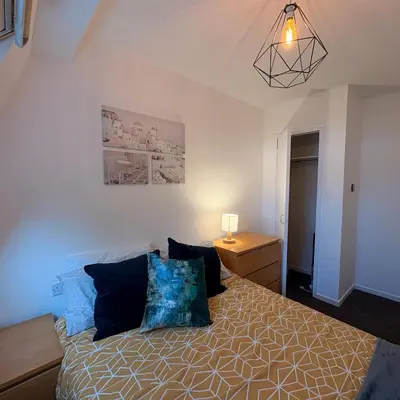 a bedroom with a bed with blue pillows at Central One-Bedroom Flat - Free Private Parking in Chesterton