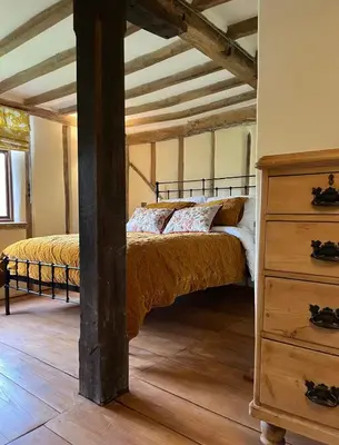 a bedroom with a bed and a dresser in a room at Park Farm in Thornham Magna