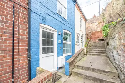 a blue building with a white door and stairs at Stones Throw, Aldeburgh in Aldeburgh