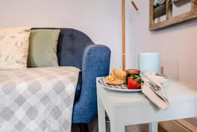 a plate of food on a table next to a bed at Stones Throw, Aldeburgh in Aldeburgh